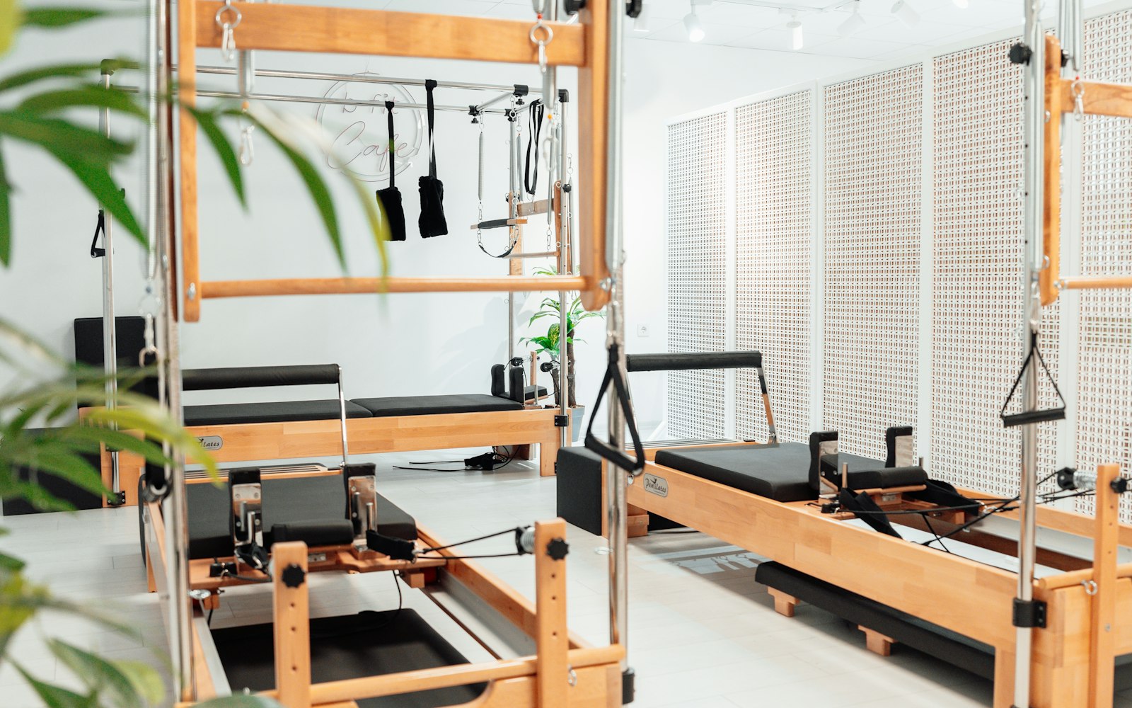 Estúdio de pilates com equipamentos reformer e ambiente iluminado